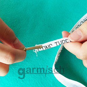 2. 夾住織帶或鬆緊帶後，將固定環往上推固定. 